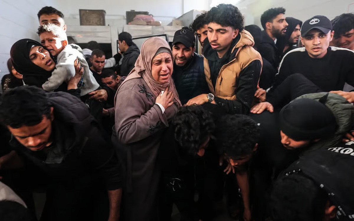 Family members mourn over the body of a Palestinian victim at the Al-Aqsa Martyrs Hospital following an Israeli strike on the Al-Maghazi refugee camp