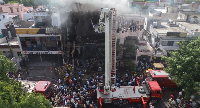 Firefighters try to douse a fire that broke out at a coaching institute