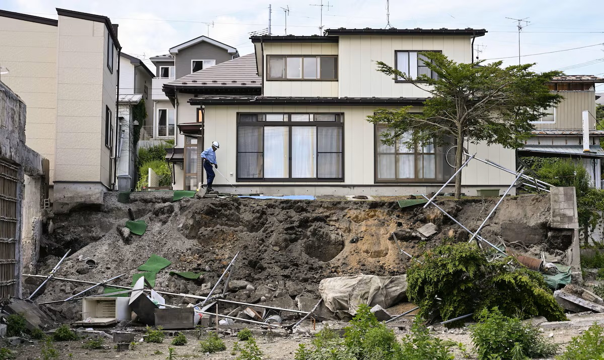A man checks a retaining wall collapsed by the earthquake in Hachinohe, Aomori Prefecture, Japan on Thursday.