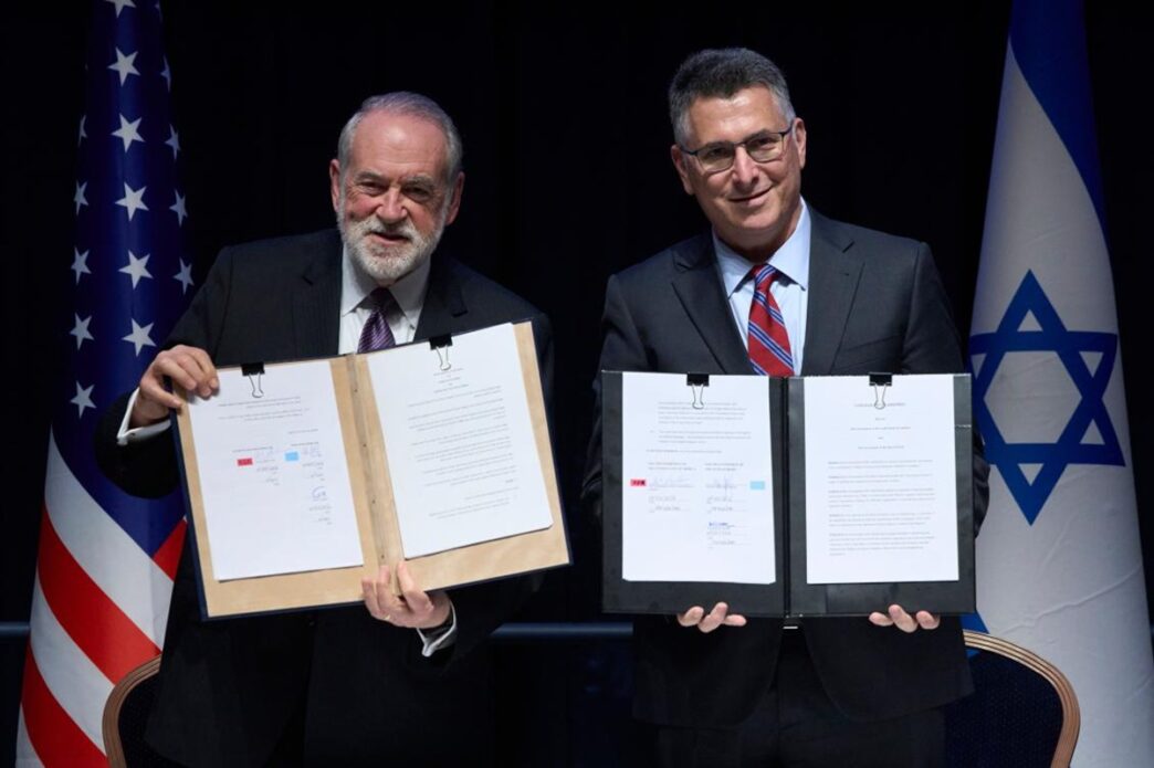 Israeli Foreign Minister Gideon Sa'ar (right) and US Ambassador to Israel Mike Huckabee present the land allocation agreement for the permanent US Embassy in Jerusalem to the audience during a ceremony on Wednesday.