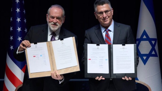 Israeli Foreign Minister Gideon Sa'ar (right) and US Ambassador to Israel Mike Huckabee present the land allocation agreement for the permanent US Embassy in Jerusalem to the audience during a ceremony on Wednesday.