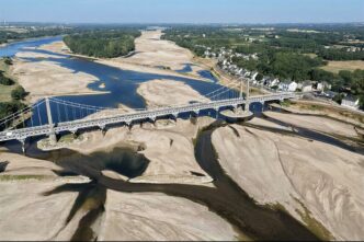 This aerial photograph shows a bridge over the dried out Loire River bed in Loireauxence (Varades), western France, on July 10, 2026