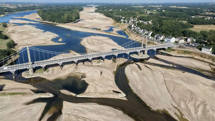This aerial photograph shows a bridge over the dried out Loire River bed in Loireauxence (Varades), western France, on July 10, 2026