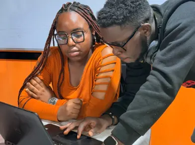 Theodora Onodugo, a backend software developer, and user of BildUp AI, troubleshooting with a colleague at the BildUp AI office in Enugu, Nigeria