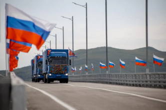 In this handout image released by the Russian Transport Ministry on September 7, 2026, national flags of Russia wave in the wind and North Korean trucks cross the new Russia-North Korea road bridge over the Tumen River, during the opening ceremony.