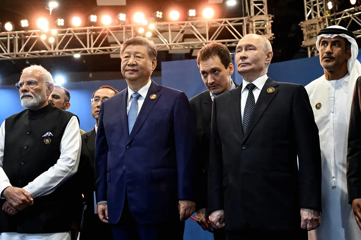 In this pool photograph distributed by the Russian state agency Sputnik, India's Prime Minister Narendra Modi (L) stands alongside China's President Xi Jinping (front C) and Russia's President Vladimir Putin (front R) during the 18th BRICS Summit in New Delhi on September 12, 2026.