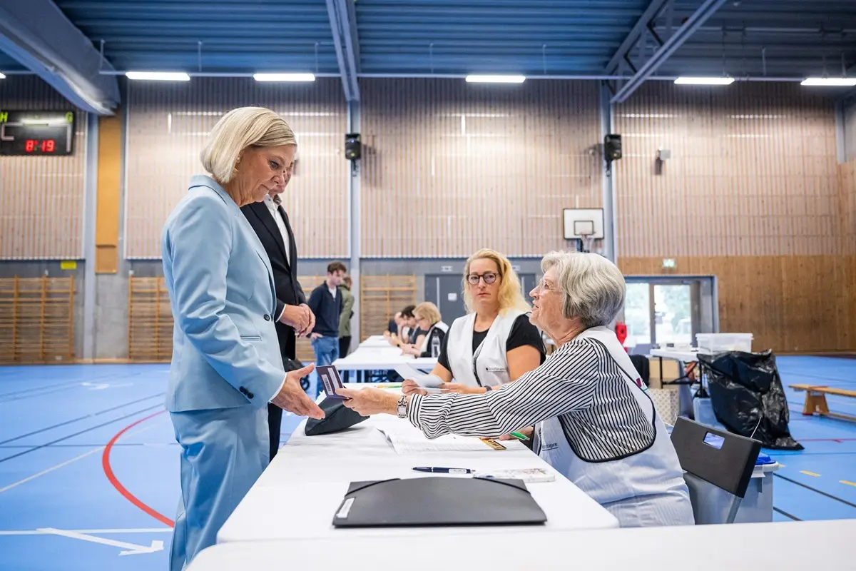 Social Democratic Party leader Magdalena Andersson (L) and her husband Richard Friberg (R) cast their vote at a polling station in a school during Sweden's general election, in Nacka on September 13, 2026.