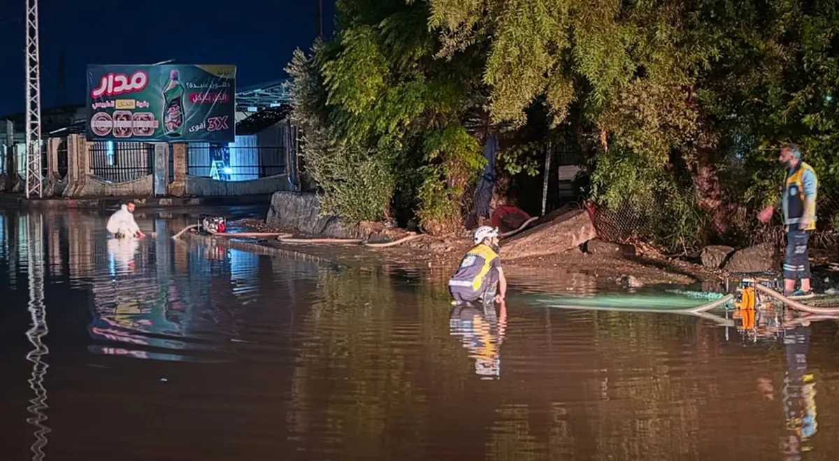 Syrian Civil Defense teams use a water-pumping truck to drain floodwater from a street following heavy rainfall in Syria, Oct. 28.
