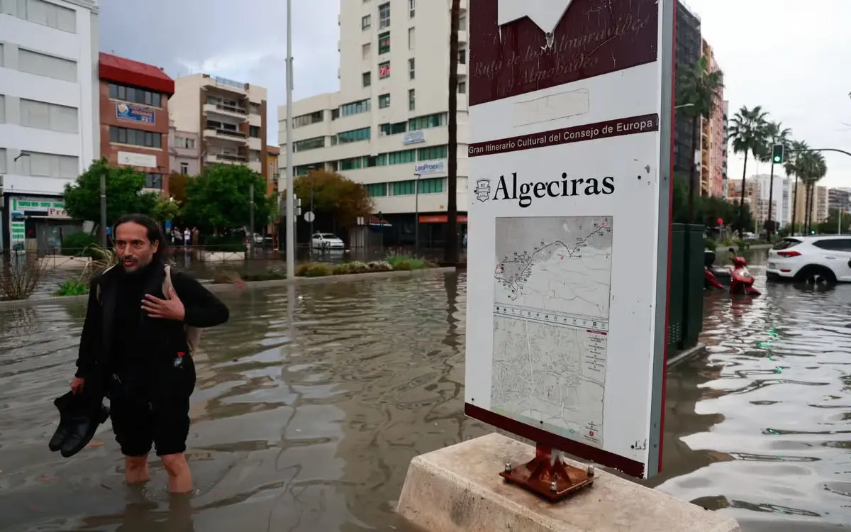 A man wades through a flooded street after heavy rainfall that hit the town of Algeciras, southern Spain.
