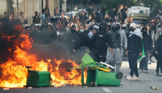 A student puts trashes into a fire as protesting students carry out blockading action near place de la Nation, in Paris, on October 2, 2026.