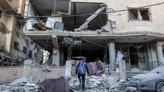 A boy walks amidst debris in a heavily-damaged building following an Israeli strike on a residential apartment in the Rimal neighbourhood of Gaza City early on October 3, 2026.