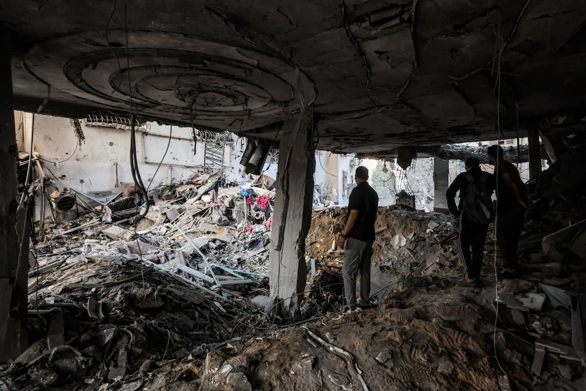 People inspect debris in a heavily-damaged building following an Israeli strike on a residential apartment in the Rimal neighbourhood of Gaza City early on October 3, 2026.