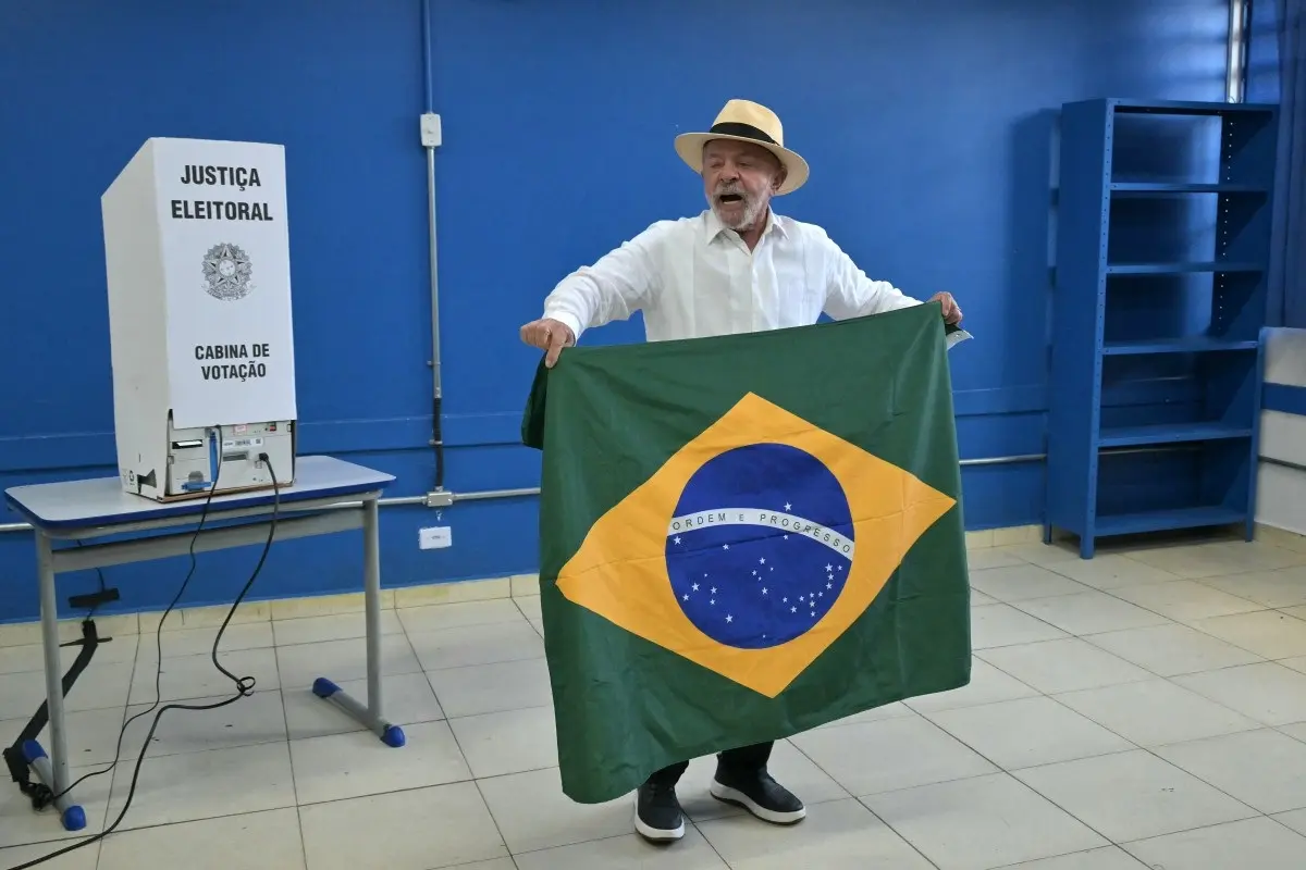Brazil's President and re-election candidate for the leftist Workers' Party (PT) Luiz Inacio Lula da Silva holds a Brazilian flag as he votes during the presidential election at a polling station in Sao Bernardo do Campo, state of Sao Paulo, Brazil, on October 4, 2026.