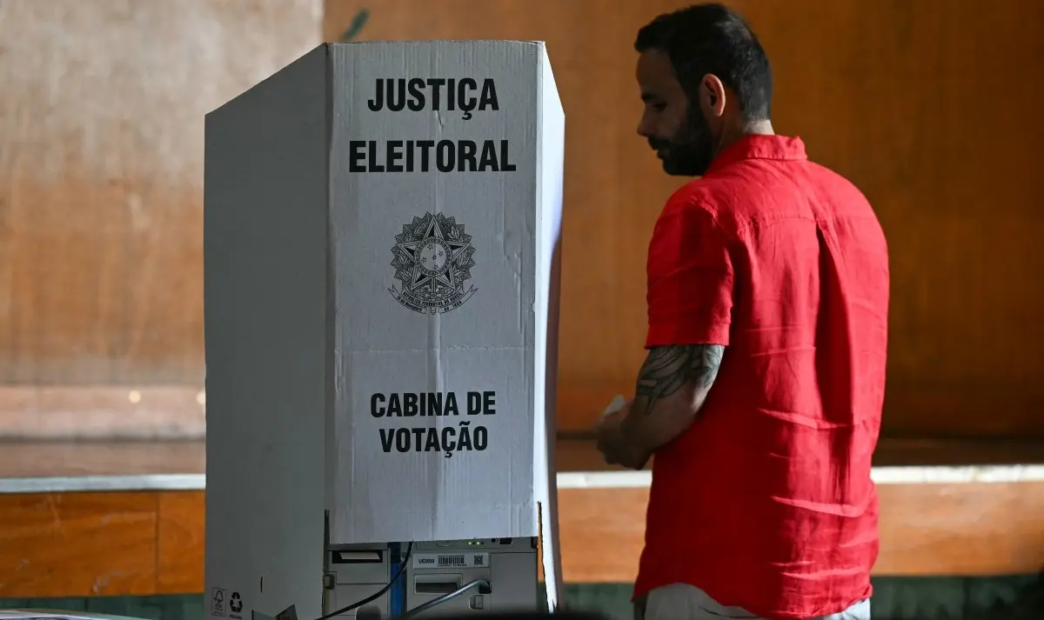 A voter stands beside a voting booth during the presidential election at a polling station in Rio de Janeiro, Brazil, on October 4, 2026.