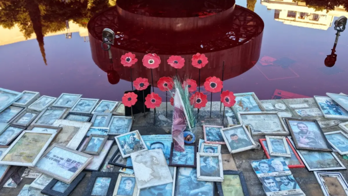 This photograph shows portraits of Israeli victims placed around the Dizengoff Fountain, filled with red dye in the Israeli coastal city of Tel Aviv on October 7, 2026, to mark the third anniversary of Hamas's October 7 attack.