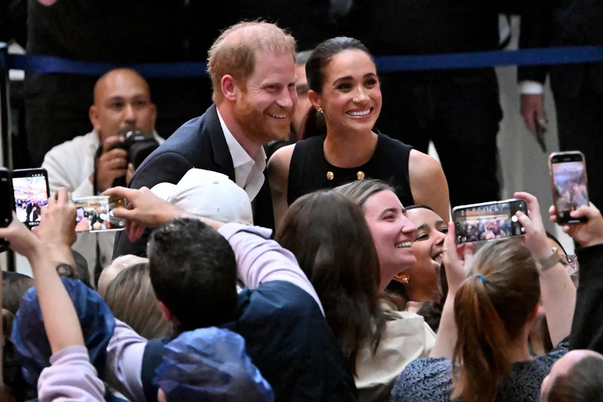Britain's Prince Harry (L), Duke of Sussex, and his wife Meghan (R), the Duchess of Sussex, meet people at the Royal Children's Hospital in Melbourne on April 14, 2026.