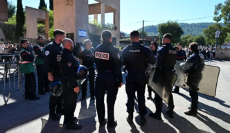 Policemen stand in front of Joseph-Lakanal middle school after a headmaster was injured by a hunting rifle shot and a teenager was arrested in Aubagne, southern France, on October 12, 2026.