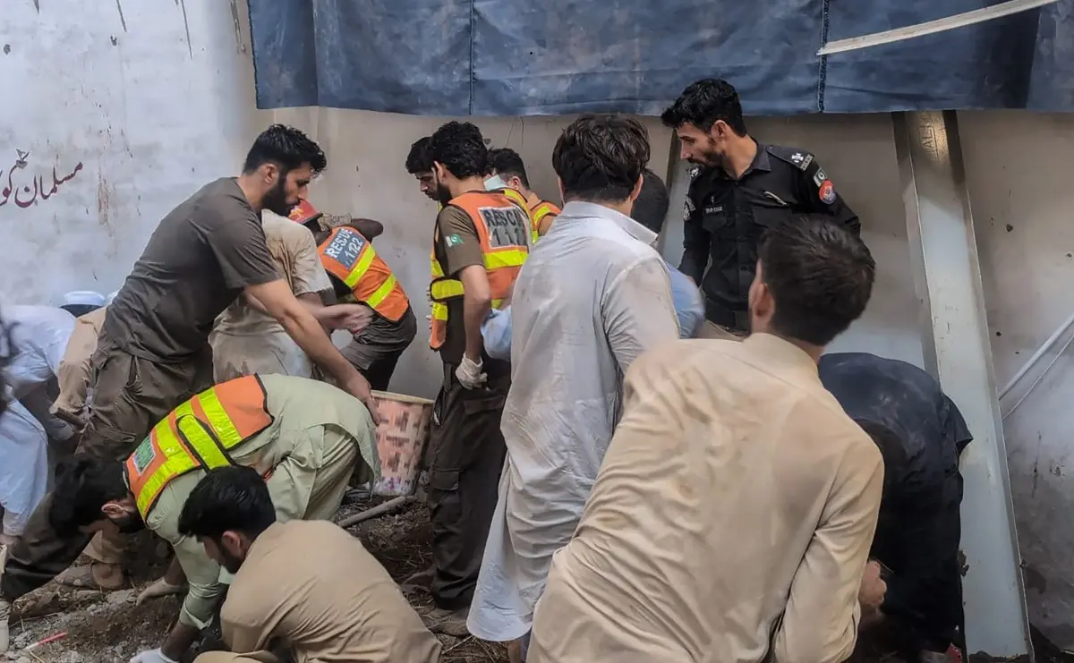 This photograph taken and released by the Khyber Pakhtunkhwa province's Emergency Service (Rescue 1122) on October 15, 2026 shows rescue workers during a search operation after a roof collapsed at a school in Peshawar.