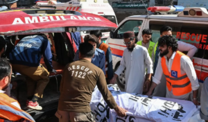 Volunteers and relatives shift the body of a victim, killed after a roof collapsed at a school, into an ambulance outside a hospital in Peshawar on October 15, 2026.