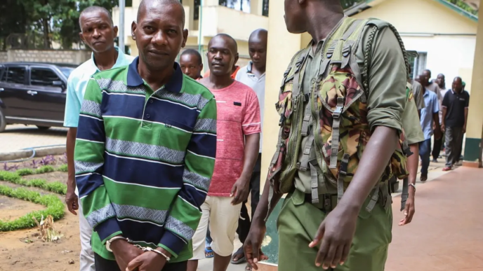 Self-proclaimed pastor Paul Nthenge Mackenzie (L) walks surrounded by Kenya Police Officers and other defendants as he appears at the Shanzu Law Courts in Mombasa on January 18, 2024.
