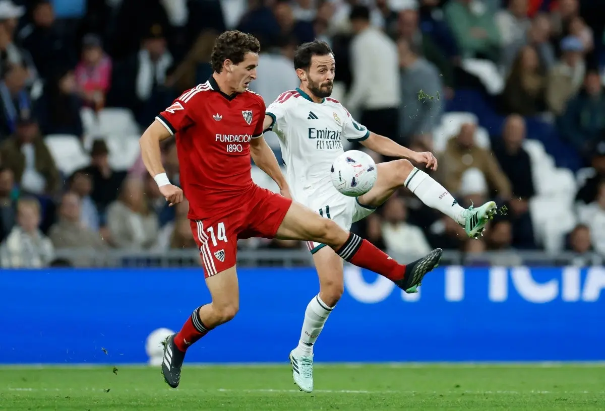 Sevilla's Spanish midfielder #14 Manu Bueno fights for the ball with Real Madrid's Portuguese midfielder #20 Bernardo Silva during the Spanish league football match between Real Madrid CF and Sevilla FC at the Santiago Bernabeu stadium in Madrid on October 18, 2026.