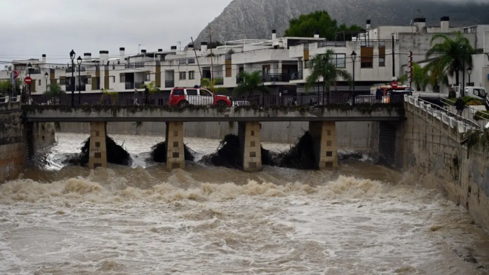 A fire service vehicle is seen on a bridge over the swollen Girona River following torrential downpours in Els Poblets, eastern Spain, on October 19, 2026.