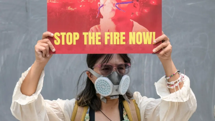 A demonstrator wearing a gas mask holds a protest placard outside China's embassy to demand an audit of supply chains linked to Indonesian forest fires, in Jakarta on October 22, 2026.