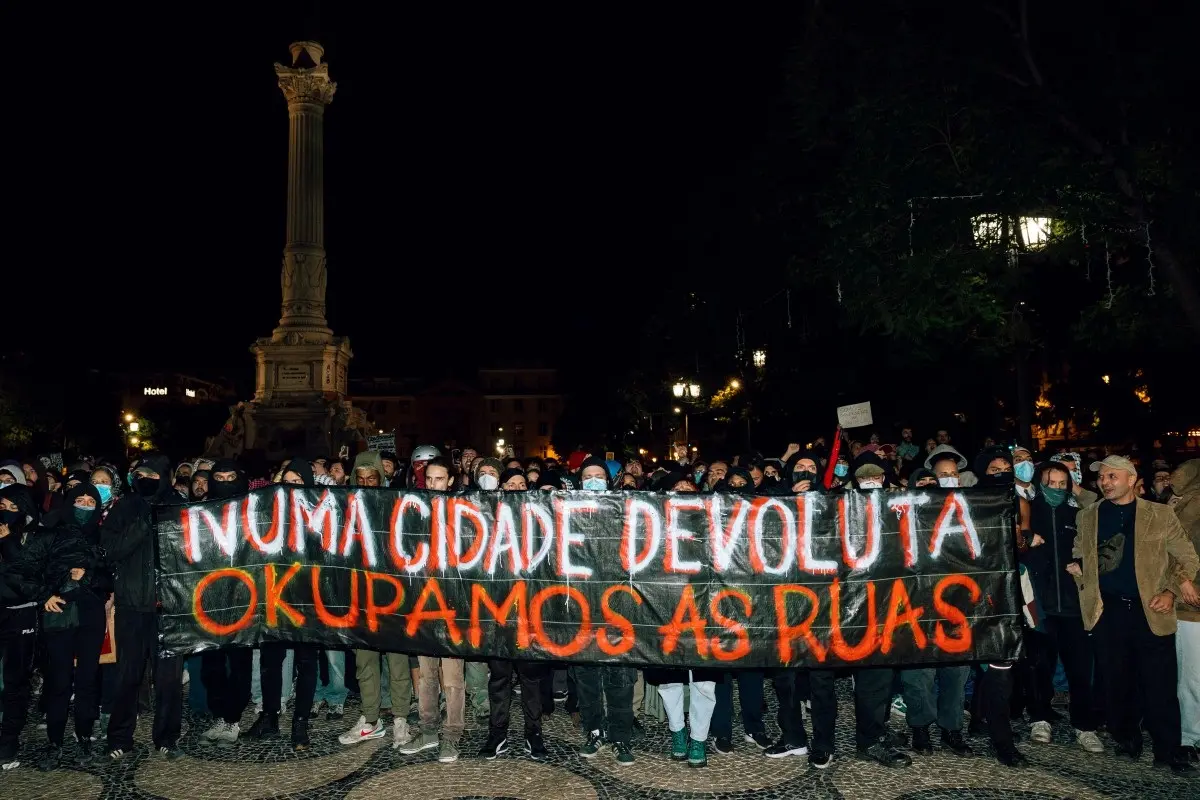 Demonstrators hold a banner reading “In a abandoned city, we occupy the streets” during a protest against the housing shortage, soaring rents and low wages at Rossio square in Lisbon, on October 25, 2026.