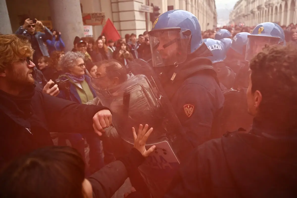 Students face Italian police officers during a demonstration part of a nationwide day of strikes and protests as school and university students demand more funding for schools and support for housing, in Turin on October 30, 2026.