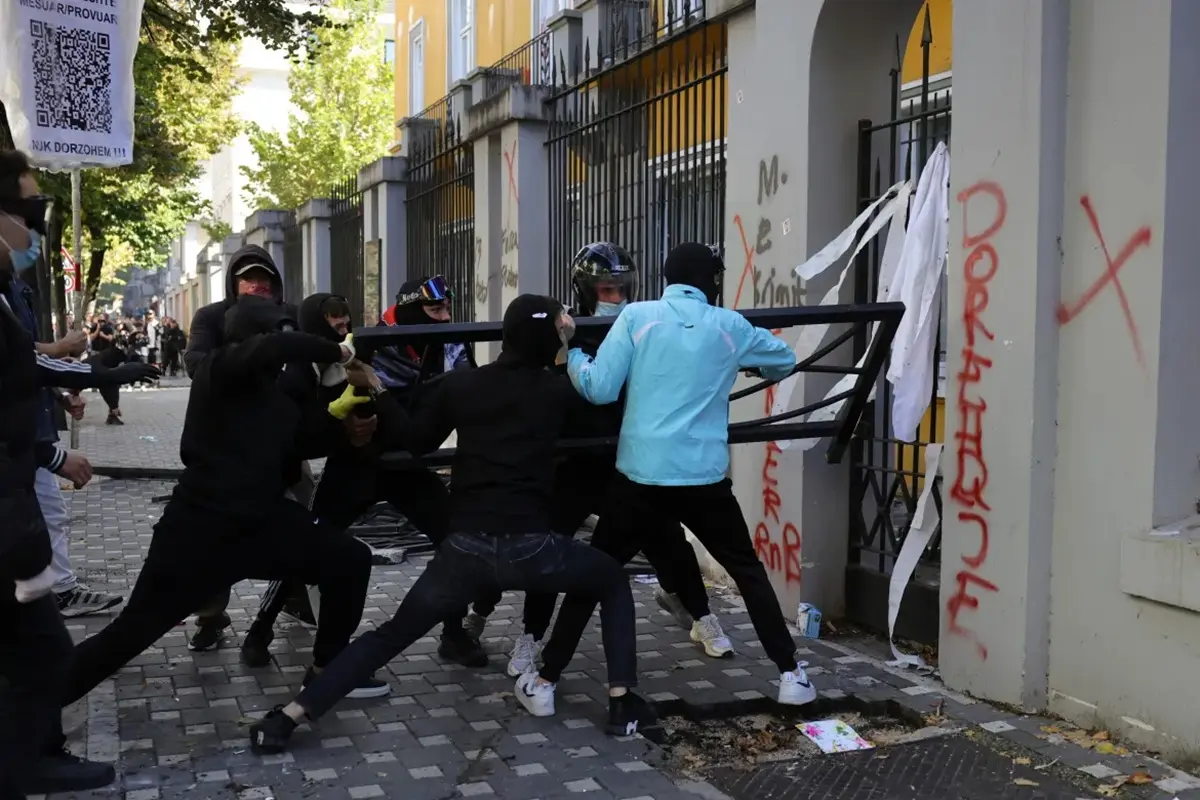 Protesters smash the Education Ministry building’s windows, tear down its perimeter fence and set billboards on fire during the clashes in the Albanian capital
