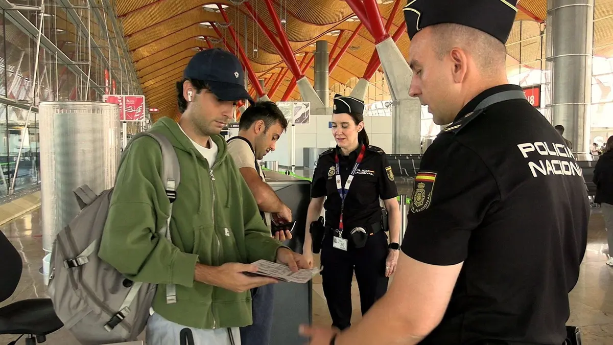 Spanish national police officers check the documents of travellers arriving from Italy, after Spain's government said it would establish border controls for flights and ships from Italy, from midnight on Saturday until September 7, in a dispute over irregular migration, at Madrid-Barajas Airport..