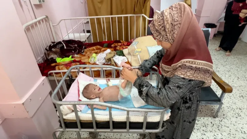 A Palestinian Mother Attends to a Malnourished Infant (News Central TV)